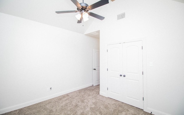 unfurnished bedroom with light carpet, vaulted ceiling, a closet, and ceiling fan