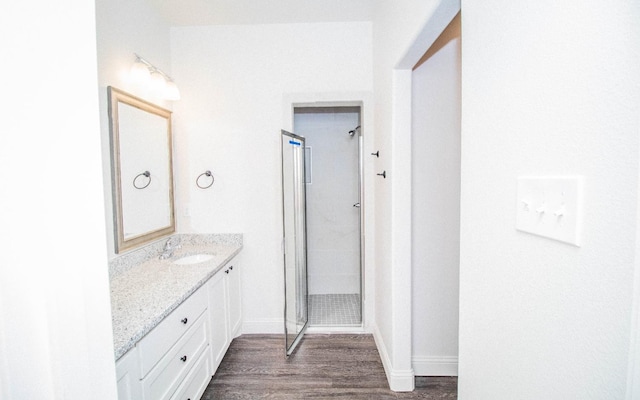 bathroom featuring hardwood / wood-style flooring, vanity, and an enclosed shower