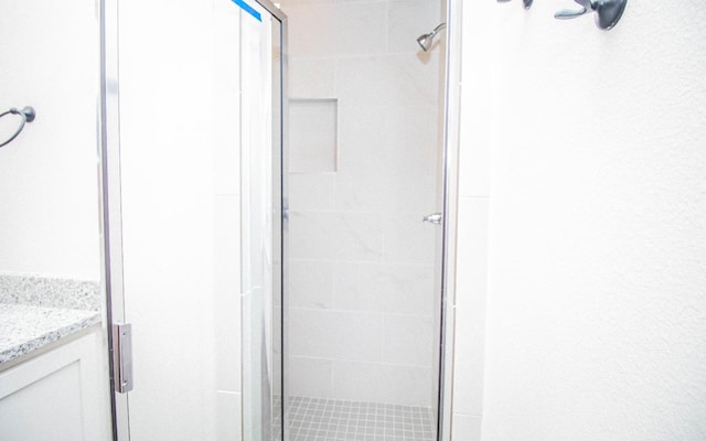 bathroom featuring vanity and a shower with shower door