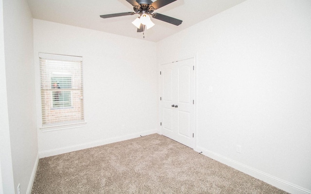 carpeted spare room featuring ceiling fan