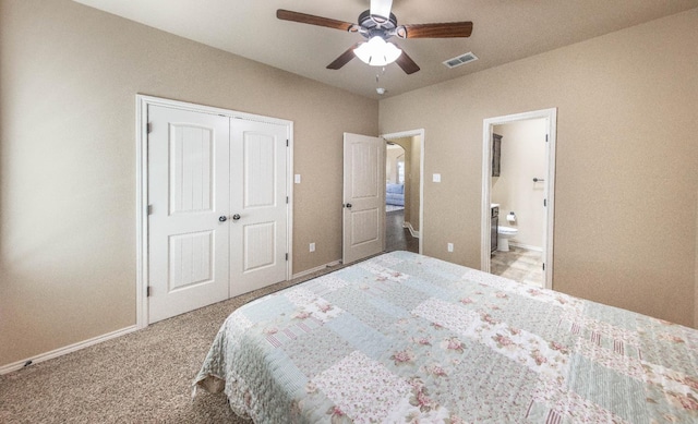 bedroom featuring ceiling fan, ensuite bath, light carpet, and a closet