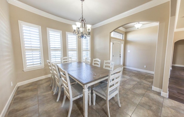 tiled dining area featuring crown molding and a chandelier