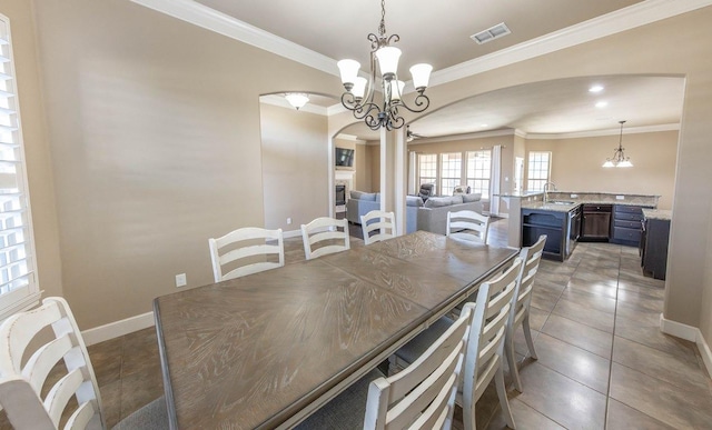 dining area featuring ornamental molding, sink, a notable chandelier, and tile patterned floors