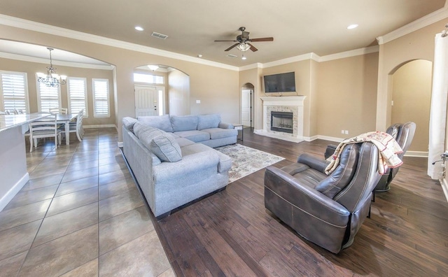 living room featuring ceiling fan with notable chandelier and ornamental molding