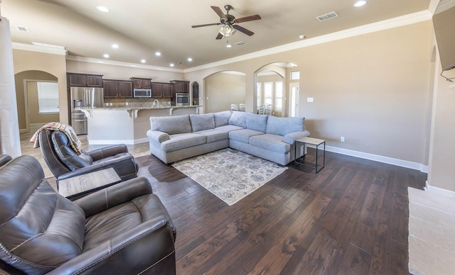 living room with crown molding, dark hardwood / wood-style floors, and ceiling fan