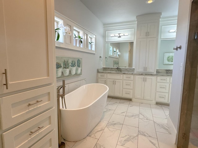 bathroom with a tub to relax in and vanity