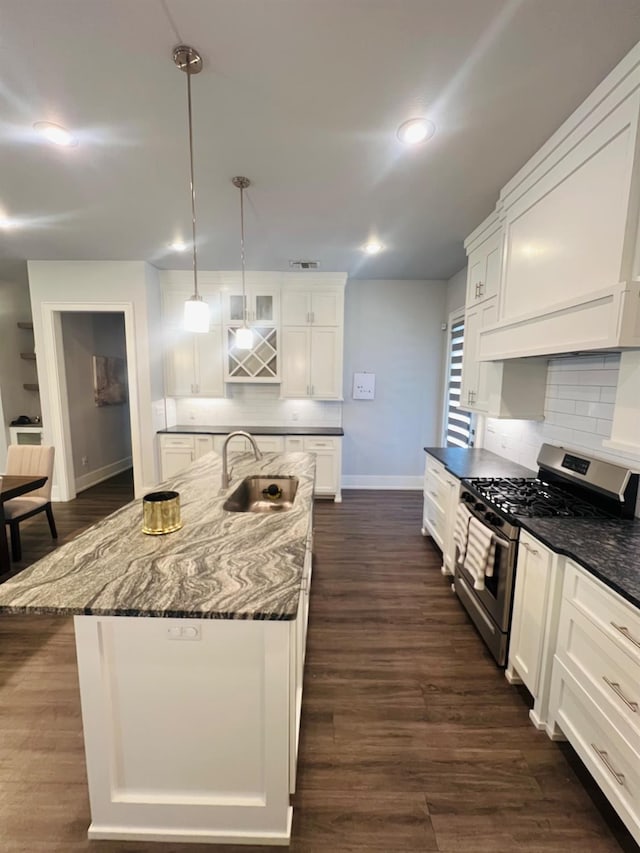 kitchen featuring sink, a kitchen island with sink, white cabinetry, decorative light fixtures, and stainless steel range with gas cooktop