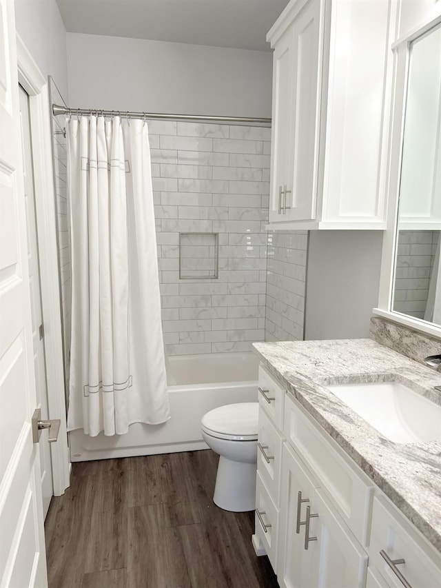 full bathroom featuring shower / tub combo with curtain, hardwood / wood-style floors, vanity, and toilet