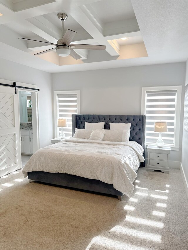 bedroom with ensuite bathroom, coffered ceiling, light carpet, ceiling fan, and a barn door