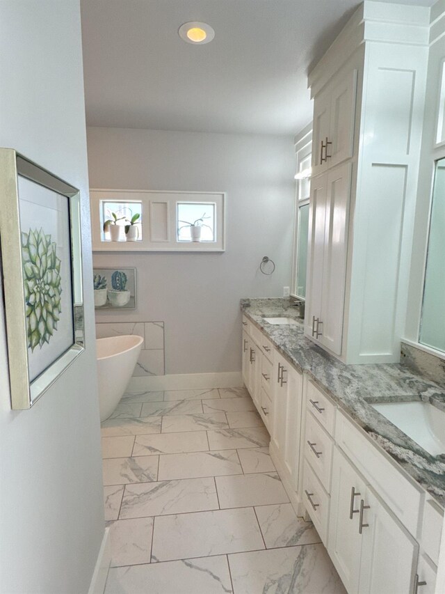 bathroom featuring vanity and a bath