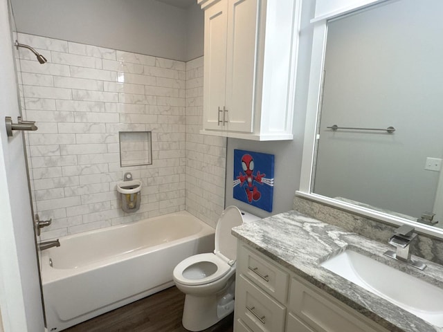 full bathroom with vanity, hardwood / wood-style flooring, toilet, and tiled shower / bath