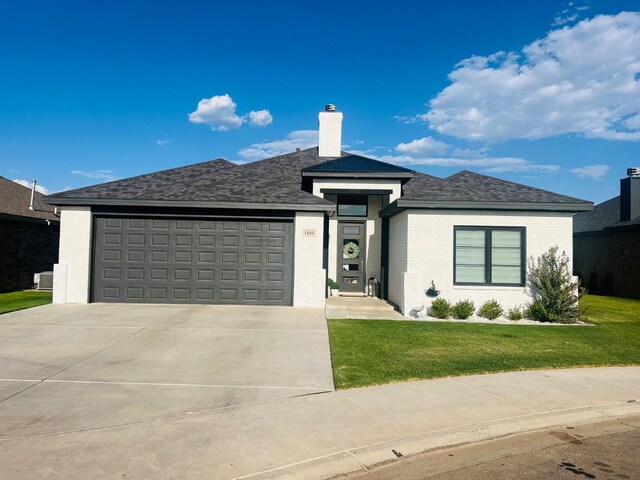 prairie-style home with a garage and a front yard