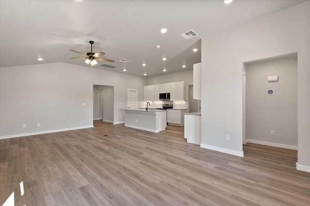 7429 30th St, Lubbock, TX 79407 - unfurnished living room with sink, light hardwood / wood-style flooring, ceiling fan, and vaulted ceiling