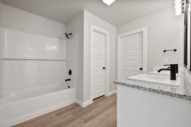 7429 30th St, Lubbock, TX 79407 - bathroom featuring vanity, wood-type flooring, and tiled shower / bath