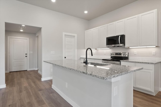 7429 30th St, Lubbock, TX 79407 - kitchen featuring appliances with stainless steel finishes, sink, a center island with sink, and white cabinets