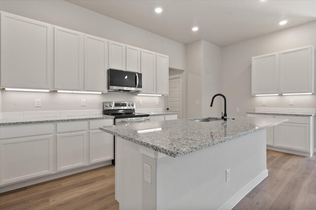 7429 30th St, Lubbock, TX 79407 - kitchen featuring white cabinetry, appliances with stainless steel finishes, sink, and a kitchen island with sink
