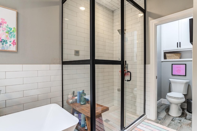 bathroom featuring toilet, hardwood / wood-style floors, and plus walk in shower