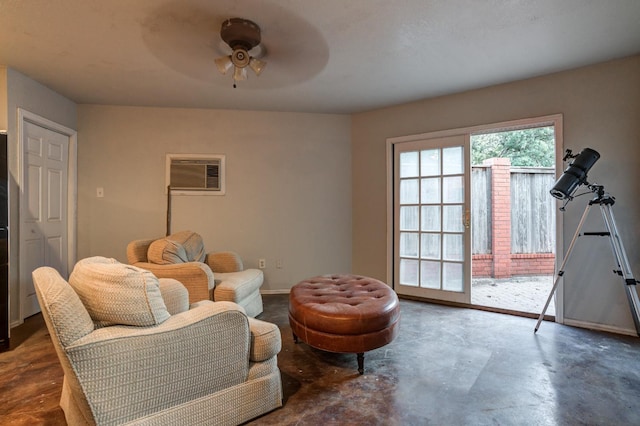 sitting room with a wall mounted air conditioner, concrete flooring, and ceiling fan