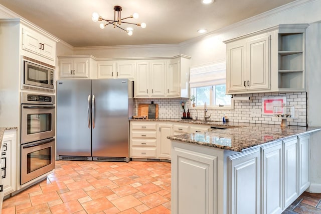 kitchen featuring white cabinets, appliances with stainless steel finishes, kitchen peninsula, and dark stone counters