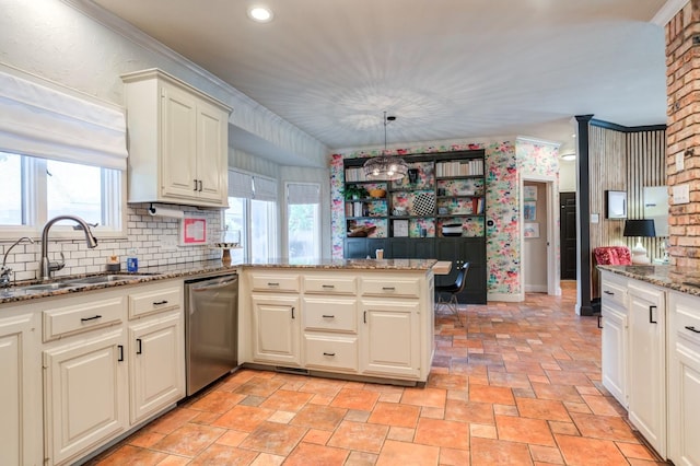 kitchen featuring sink, dishwasher, light stone counters, decorative light fixtures, and kitchen peninsula