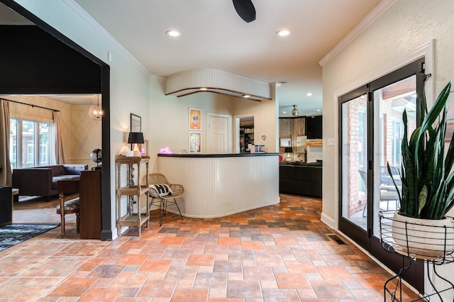 kitchen with ceiling fan, ornamental molding, and a wealth of natural light