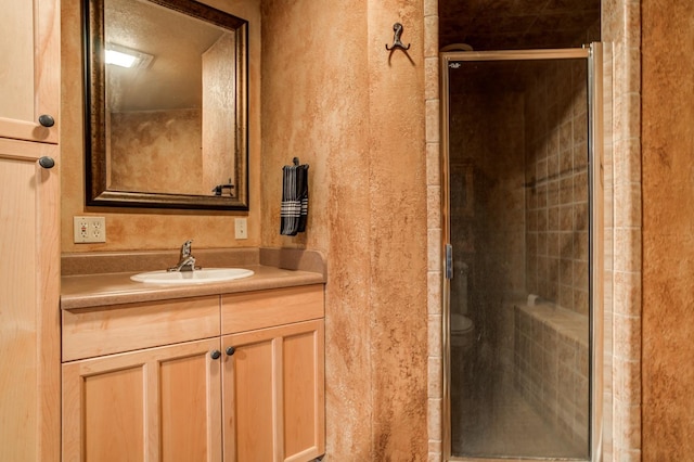 bathroom featuring walk in shower and vanity