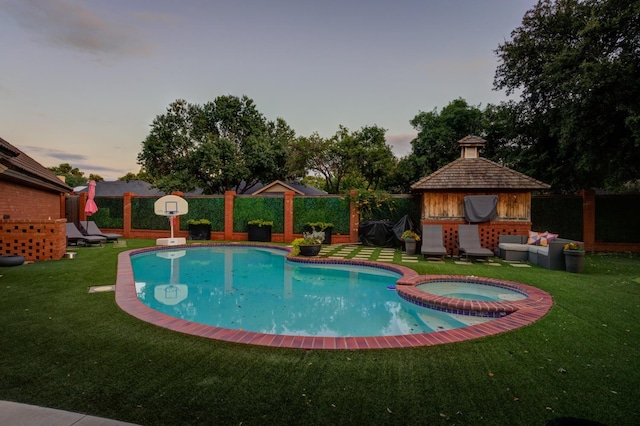 pool at dusk with a gazebo, a yard, and an in ground hot tub