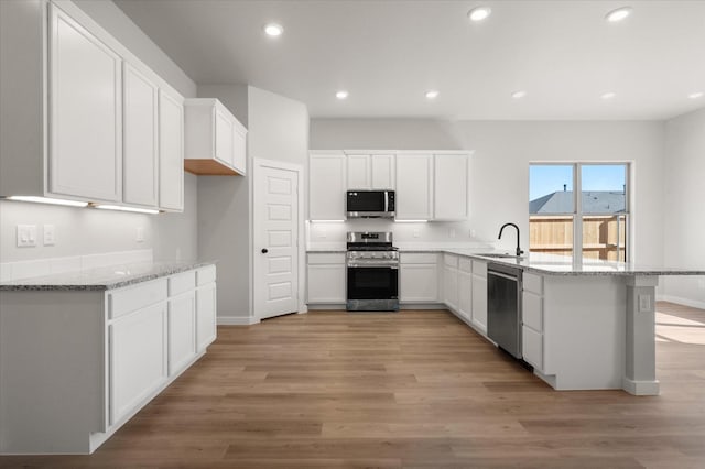 6811 54th St, Lubbock, TX 79407 - kitchen with white cabinetry, appliances with stainless steel finishes, sink, and light stone counters