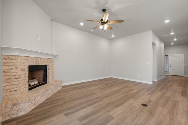 6811 54th St, Lubbock, TX 79407 - unfurnished living room featuring a brick fireplace, ceiling fan, and light hardwood / wood-style flooring