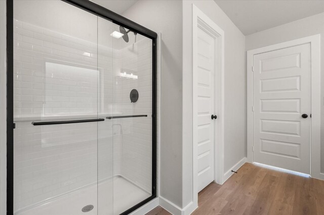 6811 54th St, Lubbock, TX 79407 - bathroom featuring wood-type flooring and an enclosed shower
