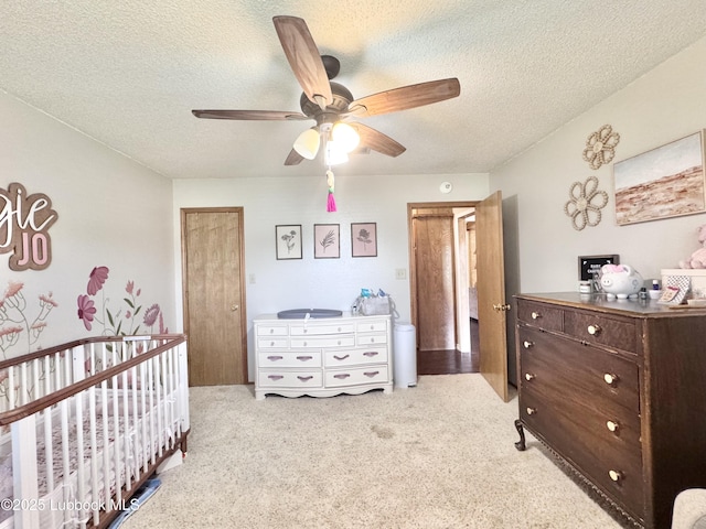 914 W Lee St, Floydada, TX 79235 - carpeted bedroom featuring a textured ceiling, a nursery area, and a ceiling fan