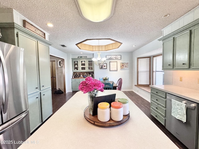 914 W Lee St, Floydada, TX 79235 - kitchen featuring appliances with stainless steel finishes, light countertops, green cabinets, a textured ceiling, and a chandelier