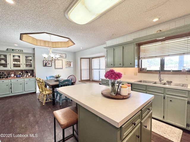 914 W Lee St, Floydada, TX 79235 - kitchen with green cabinetry, a textured ceiling, healthy amount of natural light, light countertops, and a chandelier