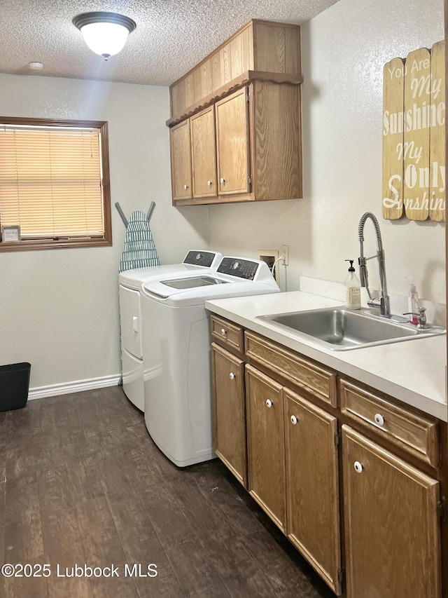 914 W Lee St, Floydada, TX 79235 - washroom featuring cabinet space, separate washer and dryer, dark wood finished floors, and a textured ceiling