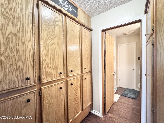 914 W Lee St, Floydada, TX 79235 - corridor featuring a textured ceiling and dark wood-style floors