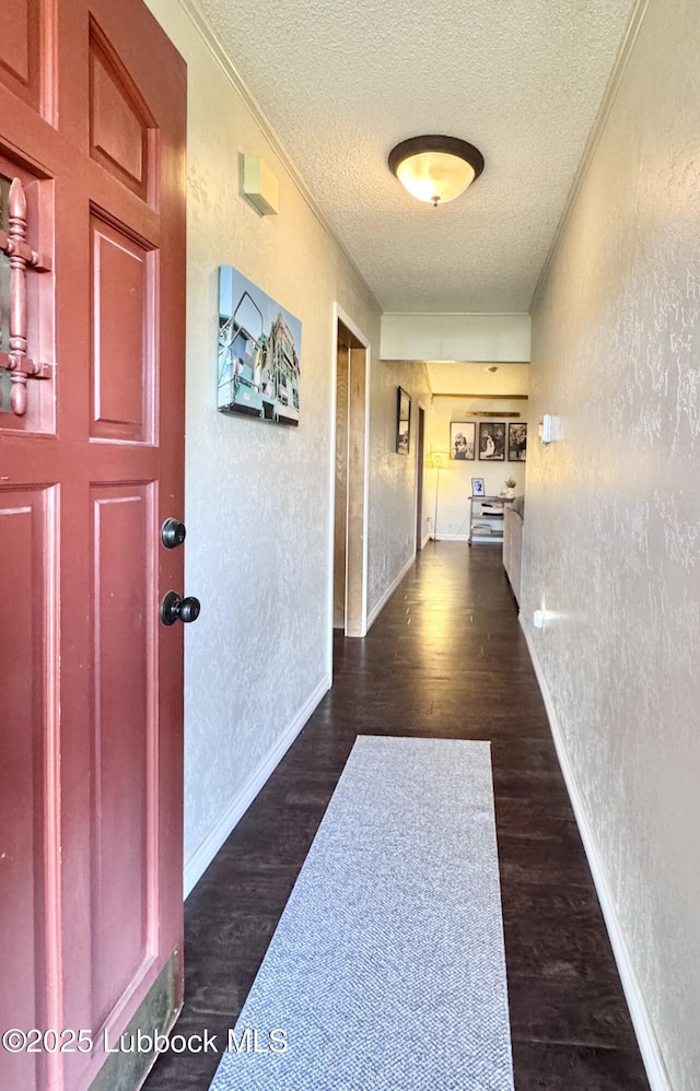 914 W Lee St, Floydada, TX 79235 - hall with a textured wall, a textured ceiling, dark wood-style flooring, and ornamental molding