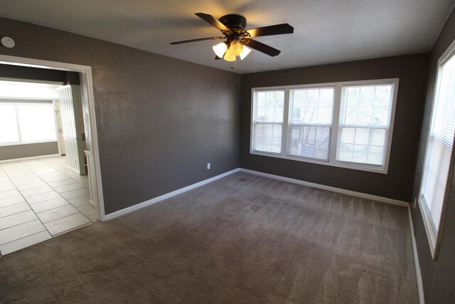 spare room featuring light colored carpet and ceiling fan