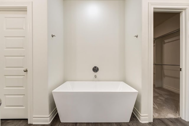 bathroom with a bath and hardwood / wood-style floors