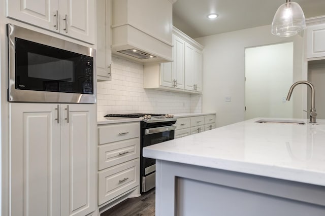 kitchen featuring sink, white cabinetry, black microwave, light stone counters, and stainless steel range oven