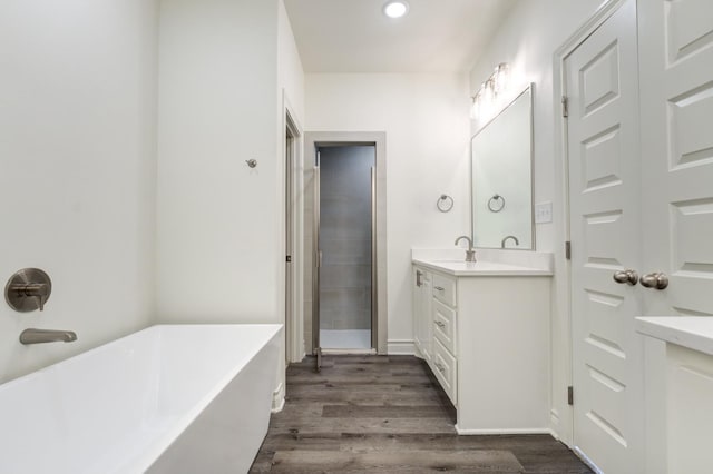 bathroom with independent shower and bath, vanity, and hardwood / wood-style floors