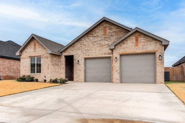 view of front of home featuring a garage and central air condition unit