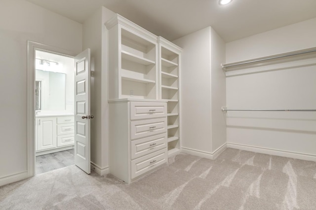 walk in closet featuring light colored carpet