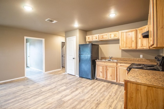 kitchen featuring light brown cabinetry, sink, black fridge, light hardwood / wood-style flooring, and range with electric stovetop