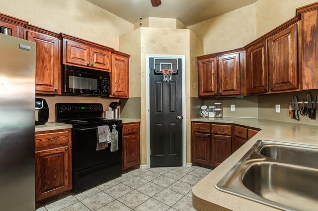 kitchen featuring ceiling fan, sink, light tile patterned floors, and black appliances