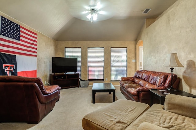 carpeted living room with ceiling fan and lofted ceiling