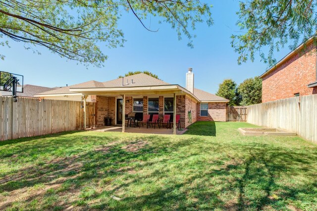 rear view of house featuring a yard and a patio