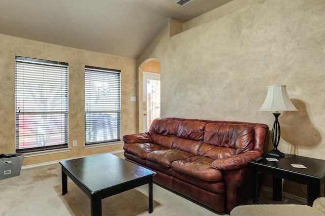 living room with lofted ceiling, light carpet, and a healthy amount of sunlight