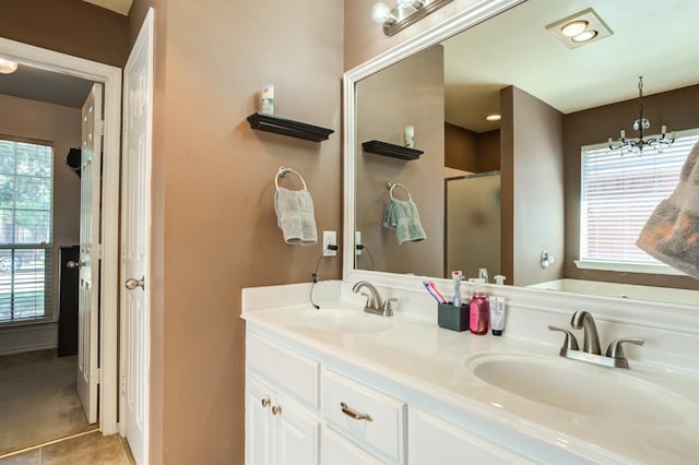 bathroom with walk in shower, vanity, a chandelier, and tile patterned flooring