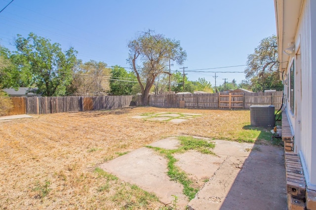 view of yard with central AC unit and a patio