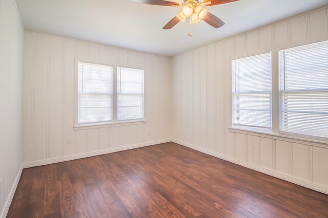 spare room with dark wood-type flooring, a wealth of natural light, and ceiling fan